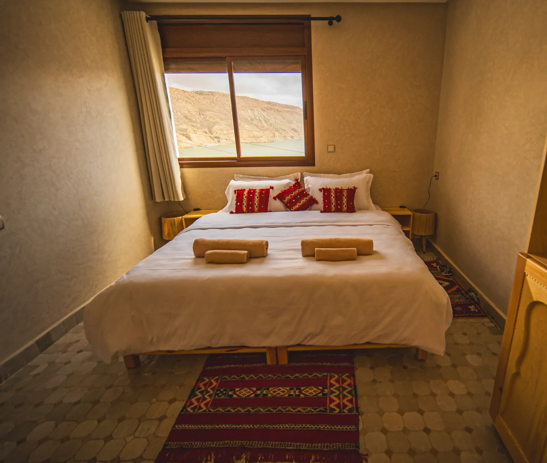 Cozy bedroom in Moroccan Surf House with a double bed and window view.'une chambre confortable à la surf house Imsouane