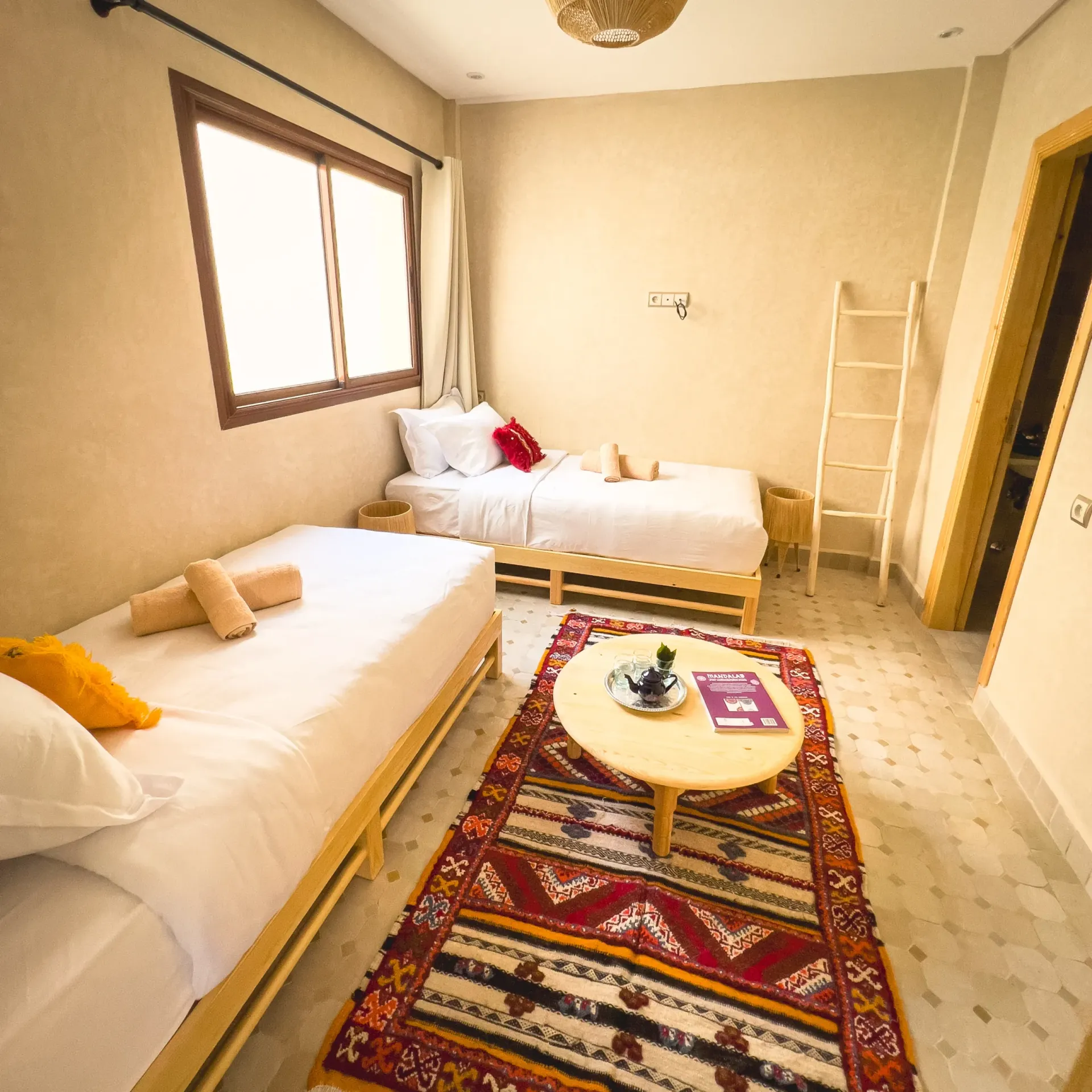 Cozy room at Moroccan Surf House with two beds and decor.