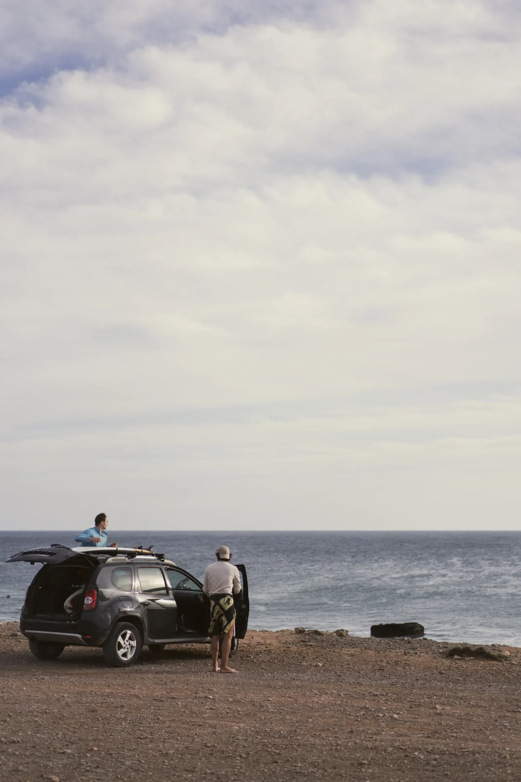 Two surfers prepare for a day at Imsouane beach, Morocco.