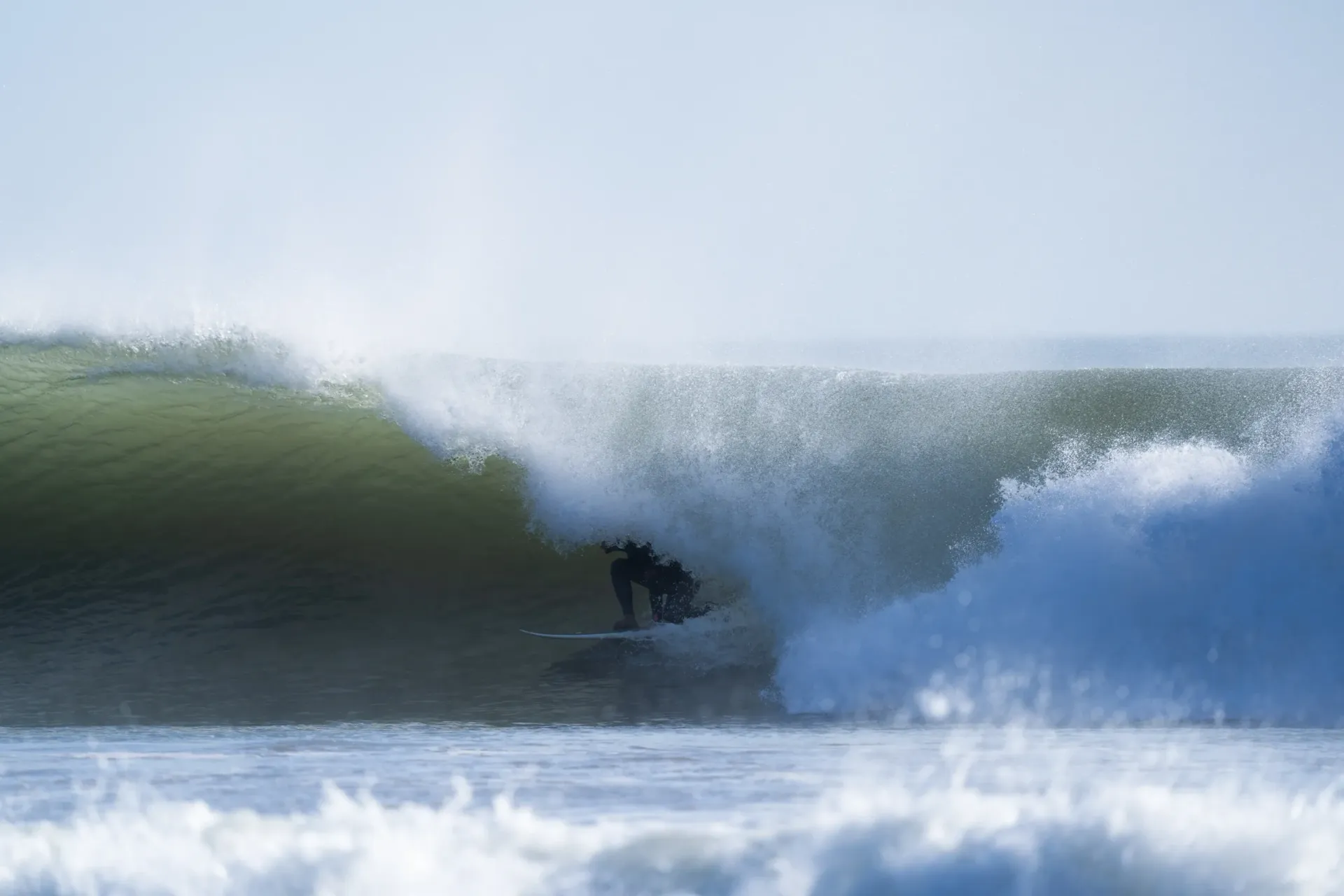 Surfer riding a large wave at Imsouane surf camp in Morocco.