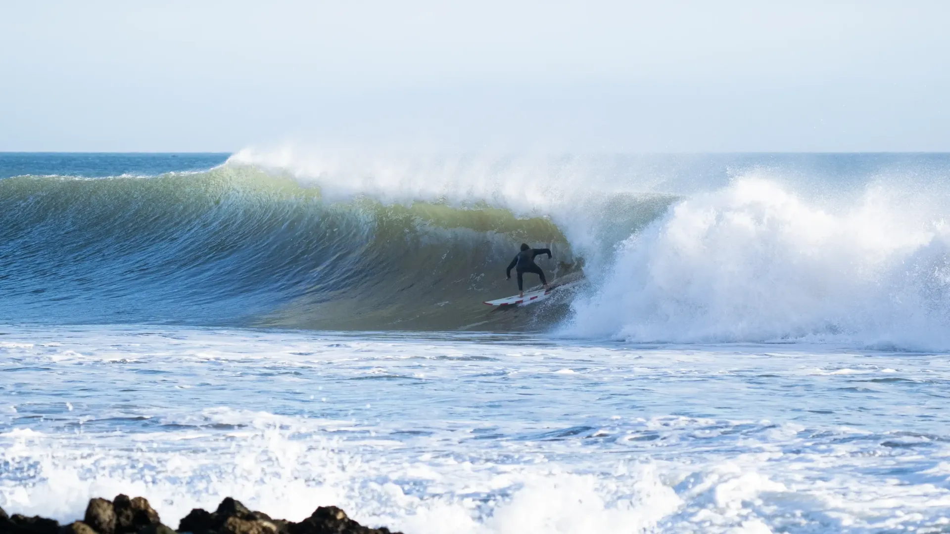 Surfer riding a large wave at Imsouane, Morocco's surf camp.
