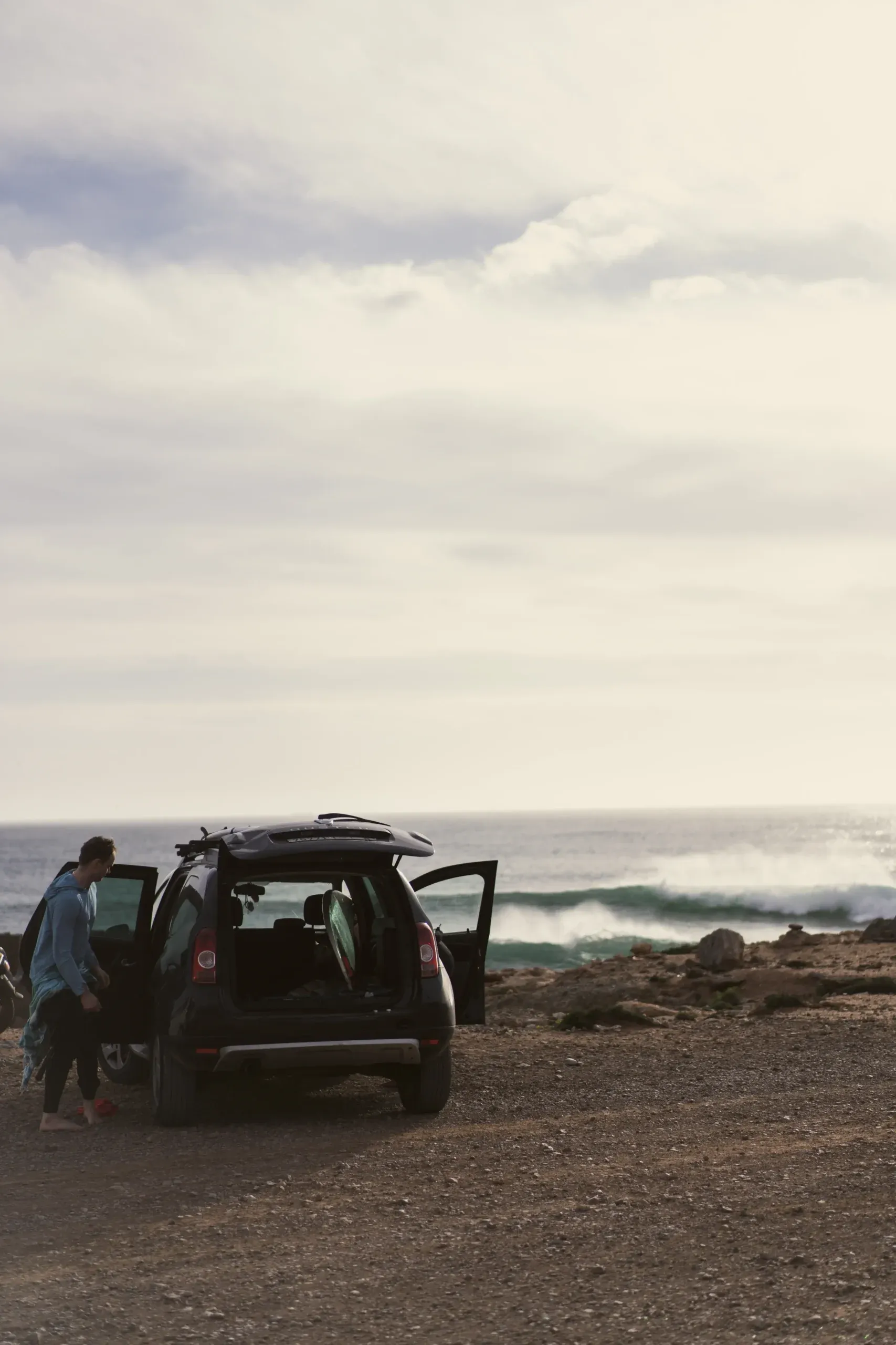 A surfer prepares for a session by the ocean near Imsouane, Morocco.