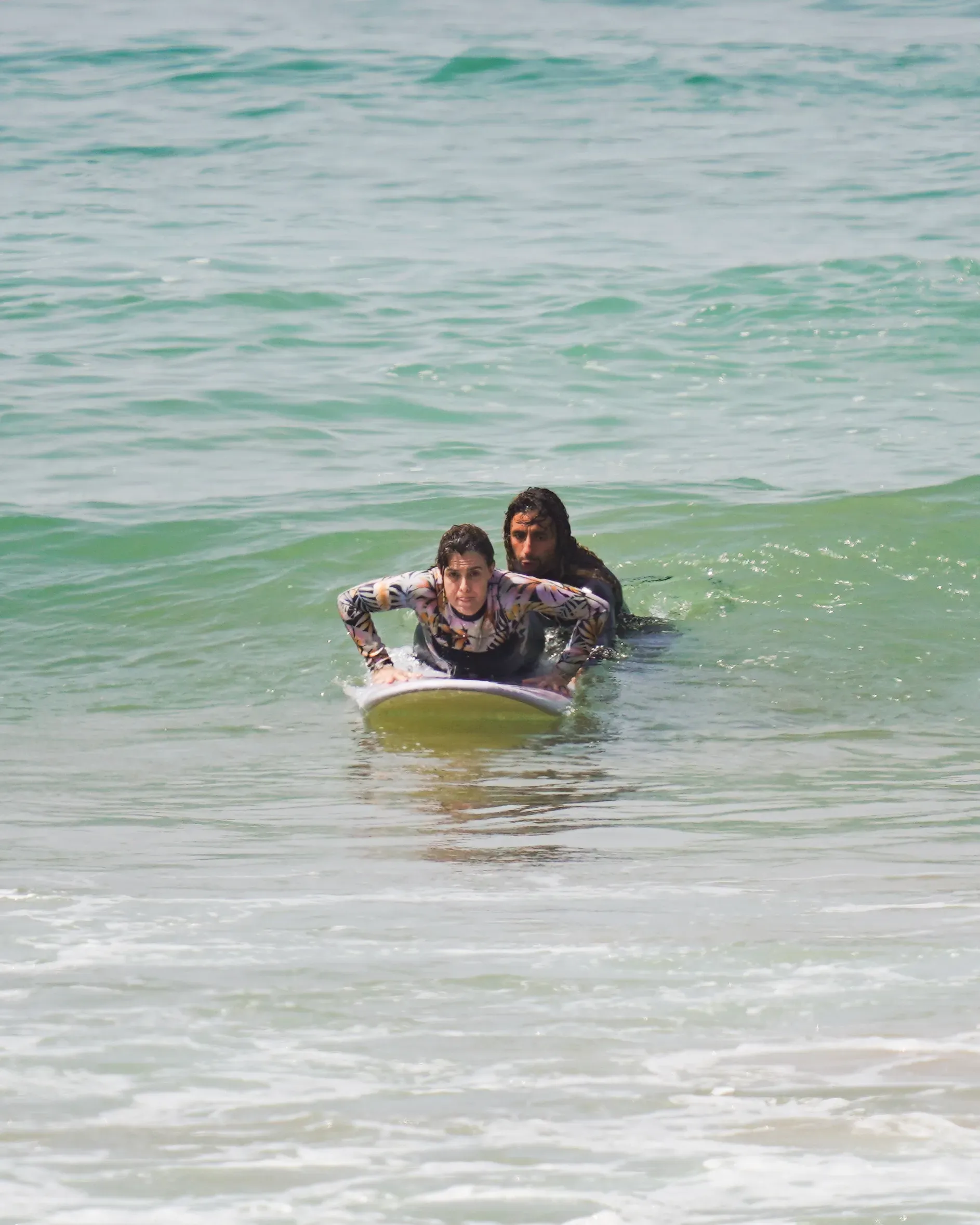 Two surfers in the water at Imsouane, preparing to ride a wave.