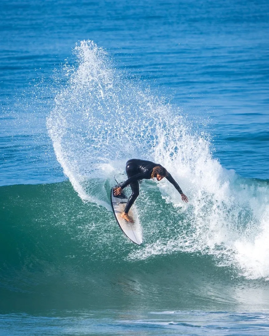 Surfer riding a wave at Imsouane surf camp in Morocco.