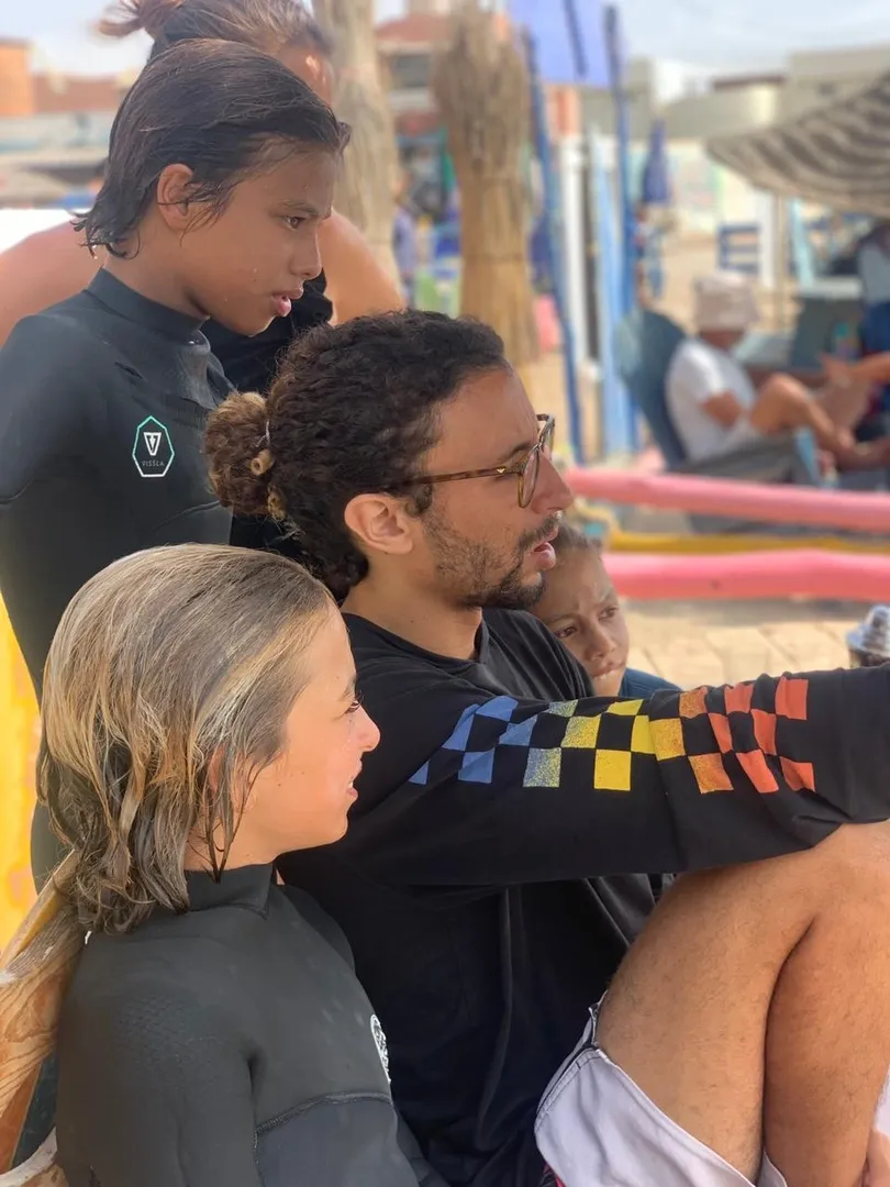 Surf instructor teaches children at Moroccan surf camp in Imsouane.